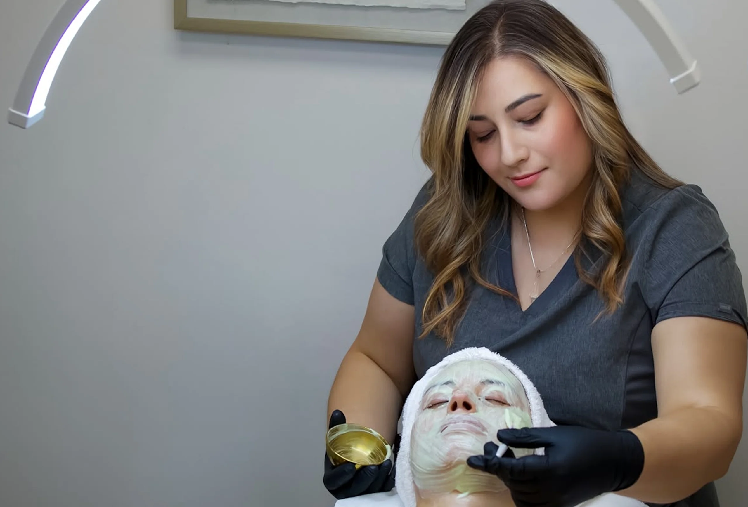 Paola aplica una mascarilla facial a una clienta en la cabina de Agapy Studio.