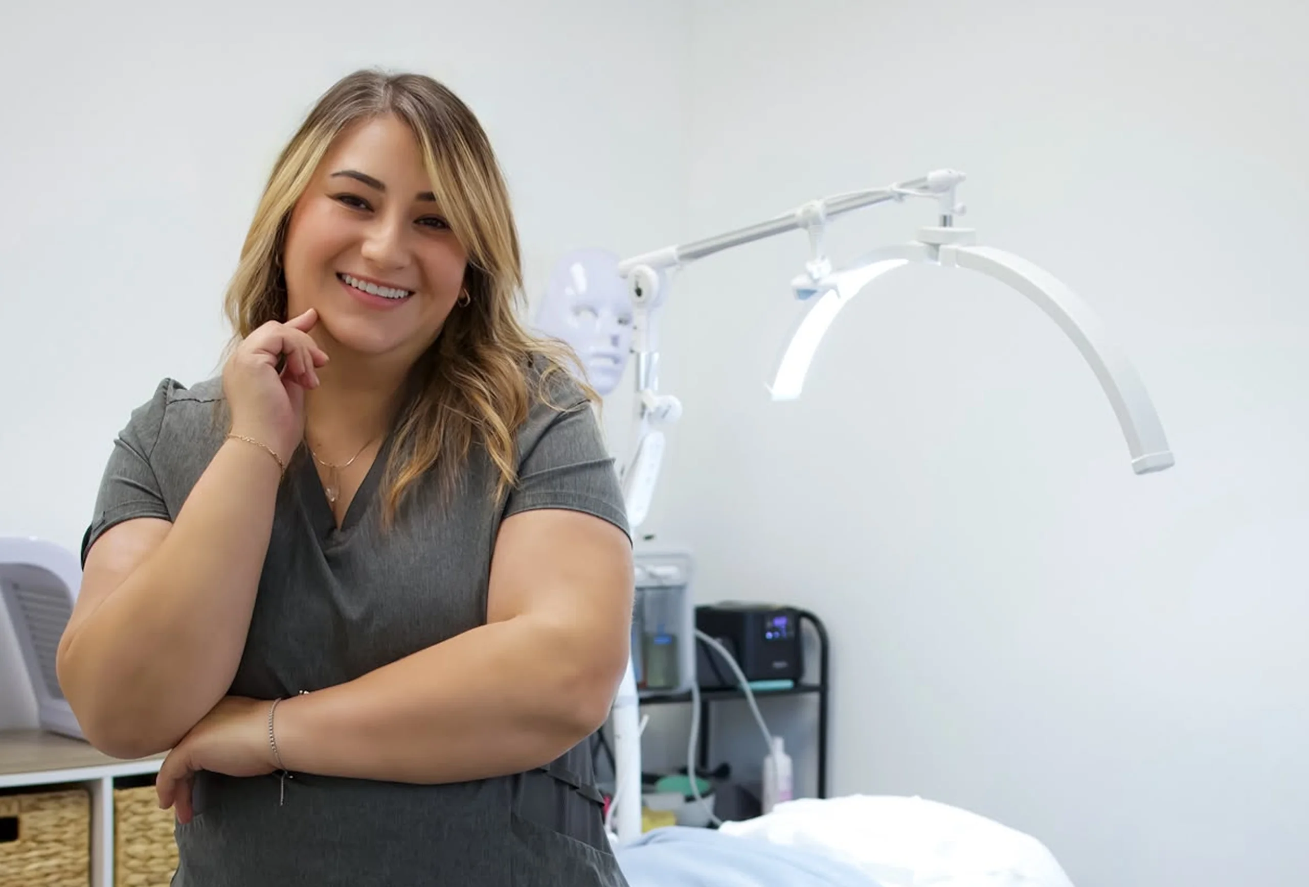 Paola sonríe en la cabina de Agapy Studio, junto a la lámpara de tratamiento.