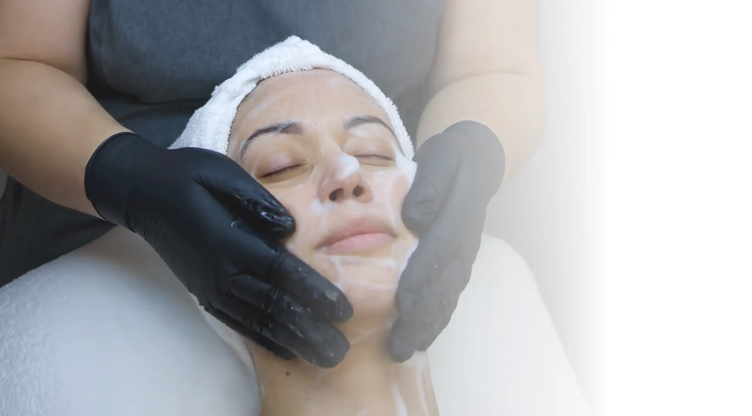 Paola masajea el rostro de una clienta durante un facial.